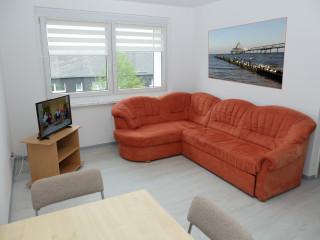 Foto: Schülerwohnungen Rodewisch von innen - Aufenthaltsraum mit einem großen Sofa und Fernseher